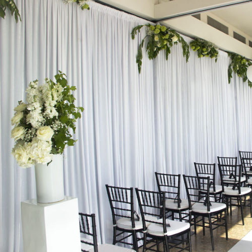 white wedding ceremony with white velvet drape