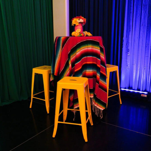 vibrant patterned throws over bar table with yellow stools