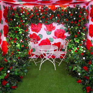 red floral columns with white wire chairs and table