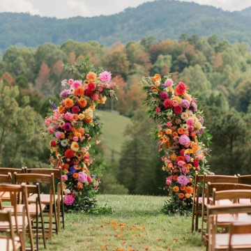 vibrant floral pillars at the end of a wedding aisle