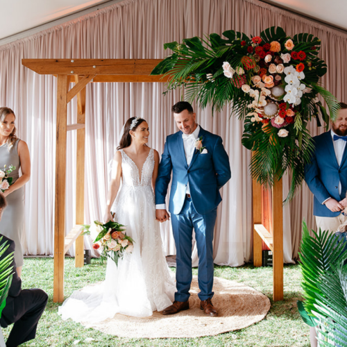 wedding arch with florals with bride and groom