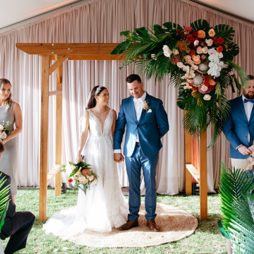 wedding arch with florals with bride and groom