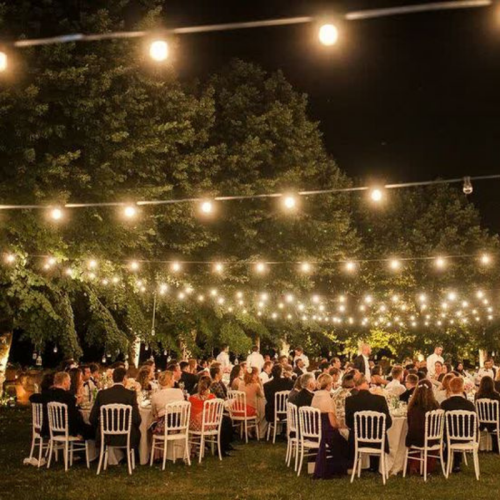 festoon lighting over wedding reception dinner tables