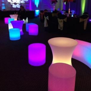 illuminated stools around a small glow bar table