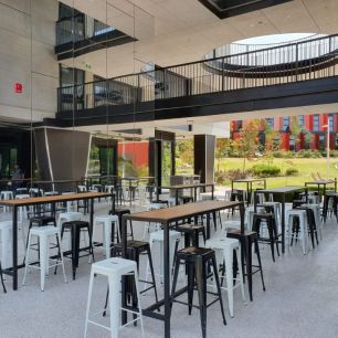 black and white bar stools around tables at a university open day