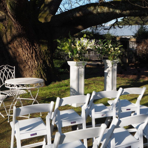 white pedestal wedding aisle floral centrepiece